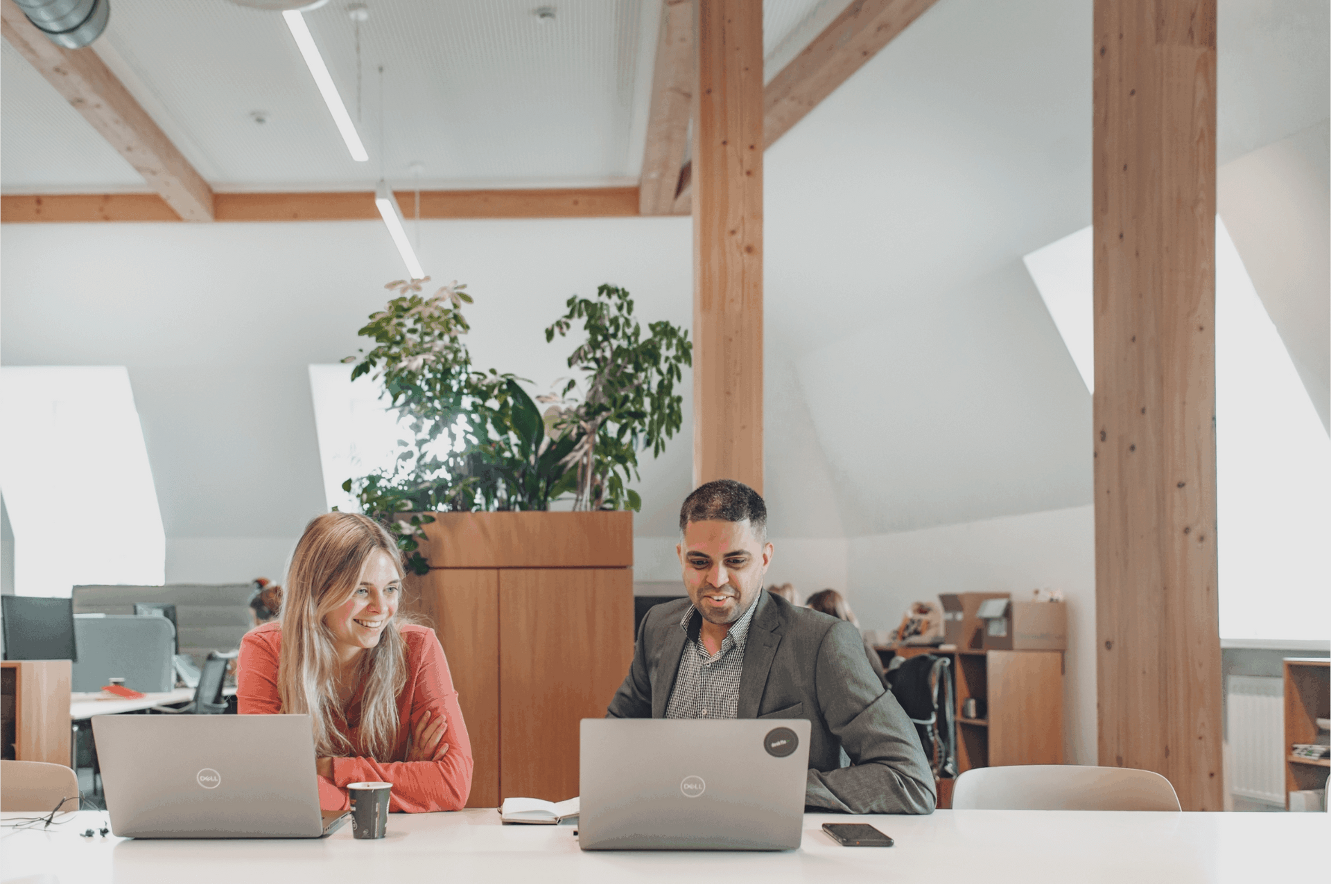 A team of diverse professionals collaborating in a bright, modern office space focused on workplace wellbeing initiatives.